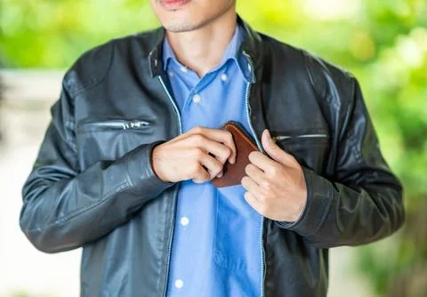 The man in leather jacket put wallet in the shirt pocket. Stock Photos