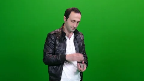 Man in Leather Jacket Shuffling Cards on Green Screen Stock Footage 83734761