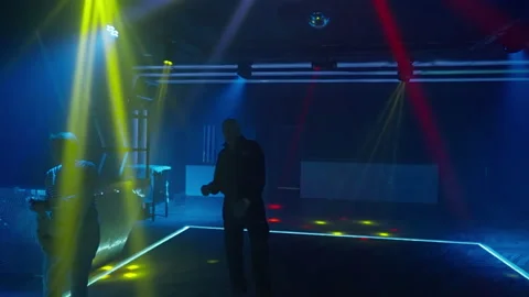 Man leaving a dance floor under colorful purple lighting Stock Footage 164932979