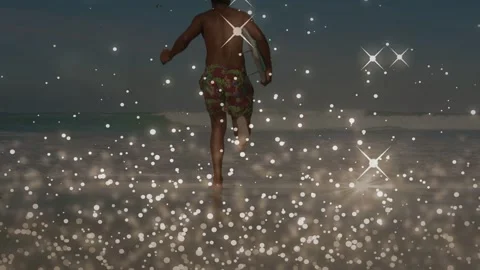 Man leaving surf running to catch waves, holding bodyboard, bokeh overlaying Видео 332545054