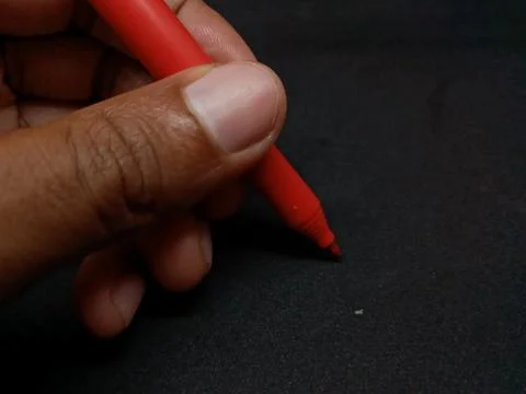 Man left hand holding a red pen. Foto stock