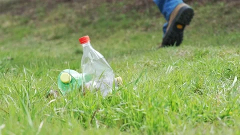 Man left used plastic bottles on green grass in the forest Stock Footage 151170272