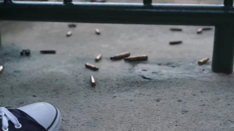 A man leg kicks fired M16 rifle bullet casings at the War Museum Vietnam 스톡 동영상 293343880