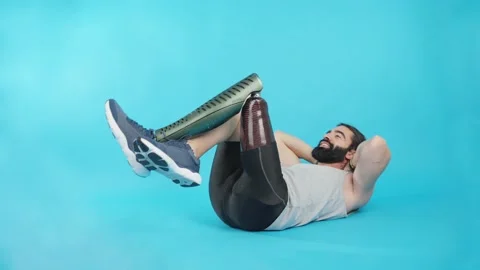Man with a leg prosthesis doing abdominal crunches 스톡 동영상 228010949