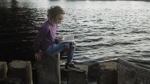 Man with leg prosthesis reads textbook sitting on stairs Stock-Footage 194603028