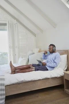 Man with leg prosthesis sitting on bed Stock Photos