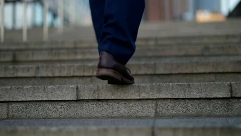 Man legs are going up over stone stairs in city, closeup view, elegant shoes and Vídeos de archivo 165944878