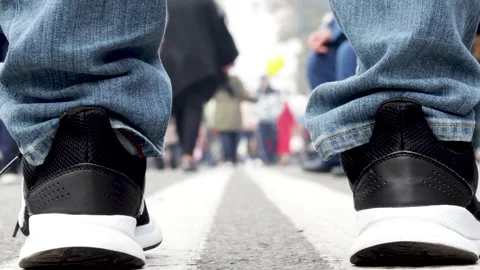 Man legs on double white line close up and lot of people walking 動画素材 219958773