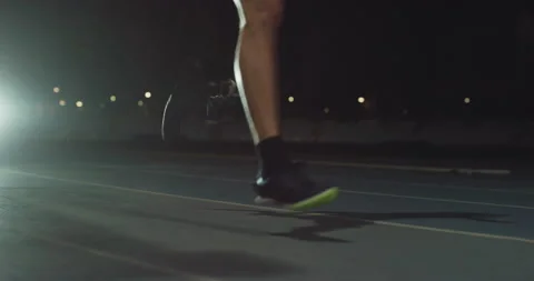 Man with legs prosthesis running with effort with racing auto at night. Stock Footage 154009643