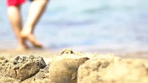 Man legs walking in water on sandy beach during summer Stock Footage 84804074