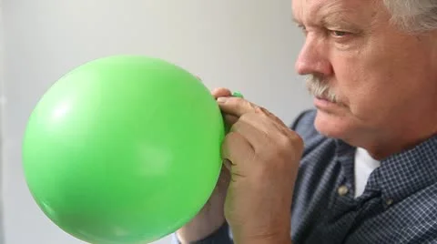 Man lets air out of balloon Stock Footage 12082798