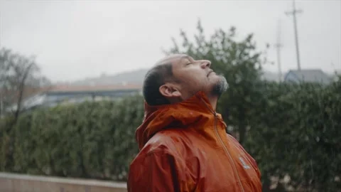 Man lets the rainwater fall on his face. Stock Footage 328937438