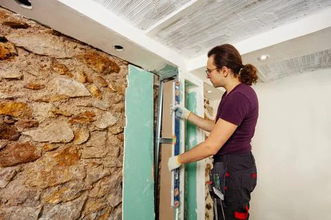 Man with a level at his home assembling drywall Stock-Fotos