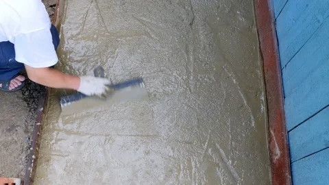 Man is leveling the cement with a spatula Stock Footage 80293693