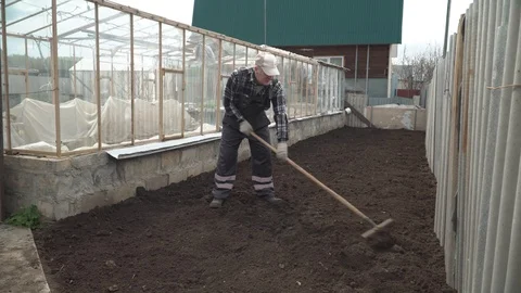 Man leveling the ground with a rake Stock Footage 96361801