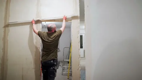 A man is leveling the plaster on the wall Stock Footage 169625023