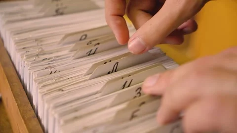 Man in the library looks through the cards  Vídeos de archivo 156512150