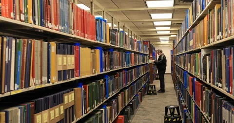 Man in library reading research books 4K Stock-Footage 102415663