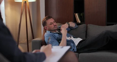 Man lies on couch sharing personal life problems in therapy room. Woman Stock Footage 324476939