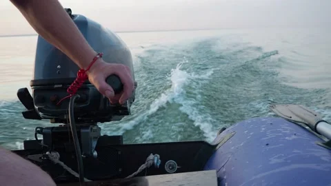 Man in life jacket drives a motorised rubber inflatable boat. Close-up of hand Stock Footage 148169635