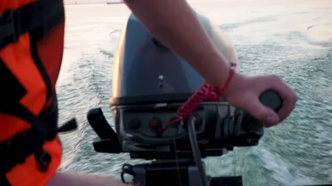 Man in life jacket drives a motorised rubber inflatable boat. Close-up of hand Stock Footage 148333882