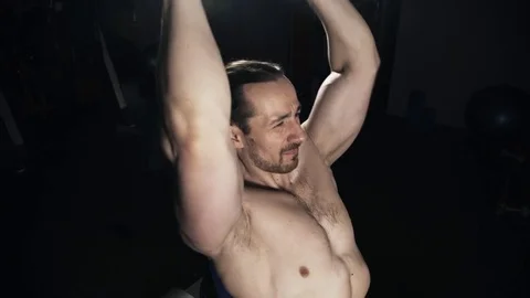 Man lifting barbell behind his head with an effort Stock Footage