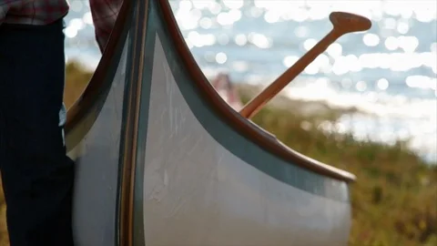 Man lifting canoe on riverside. 스톡 동영상 88405725