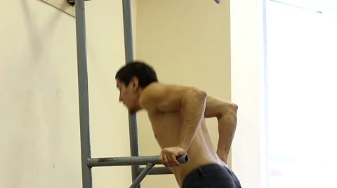 Man lifting up his bodyweight while exercising on parallel bars Stock Footage 67593802