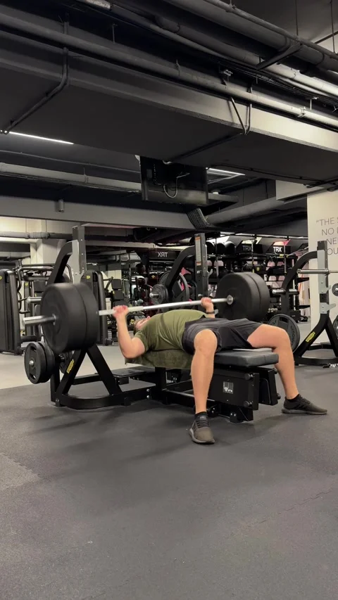 Man lifting weights on a bench for chest workout, building strength and muscles Stock Footage 339600903