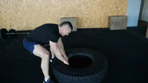 Man lifts a large tire while working out crossfit exercising - fitness workout Stock Footage 102066240