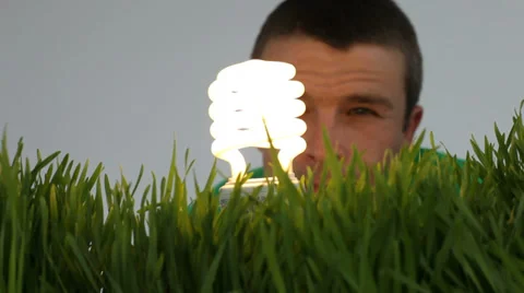 Man with light bulb and grass patch Stock Footage 32716273