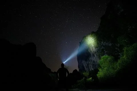 Man With Light On Cliff Foto stock