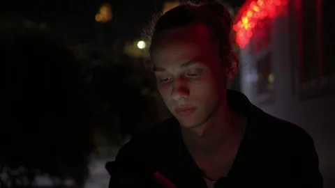 Man lighted of red light use smartphone on the street aytnight 12 Video stock 95860891