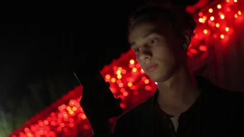 Man lighted of red light use smartphone on the street at night 8 Stock Footage 95862004