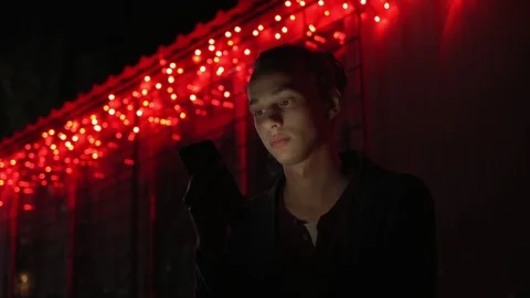 Man lighted of red light use smartphone on the street at night 6 Video stock 95862117