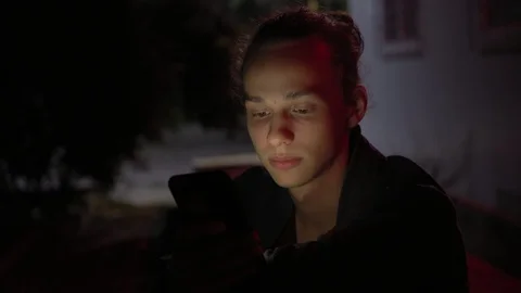 Man lighted of red light use smartphone on the street at night 5 Stockbeeldmateriaal 95863429