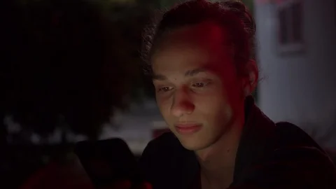 Man lighted of red light use smartphone on the street at night 4 Stock Footage 95863773