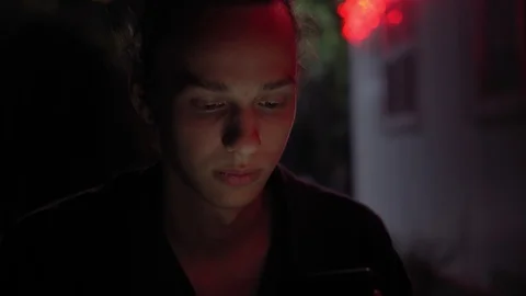 Man lighted of red light use smartphone on the street at night 1 Video stock 95864154
