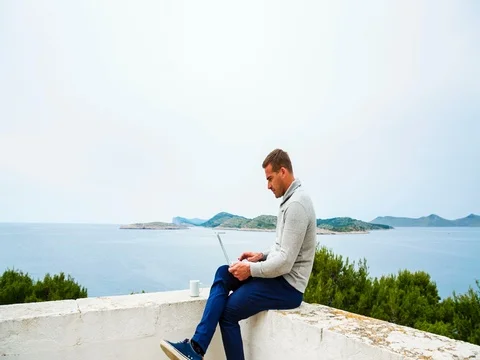 Man by lighthouse with laptop Vídeos de archivo 72959683