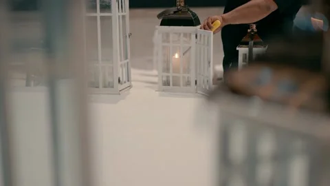 A man lighting a candle and putting it in a white vintage style lamp. Video stock 230156750