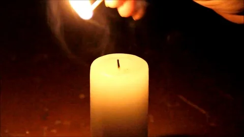 Man lighting a candle in the darkness and blowing it out Stock Footage 77862552