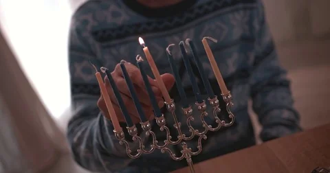 Man lighting candles on menorah celebrating Hanukah Stock Footage
