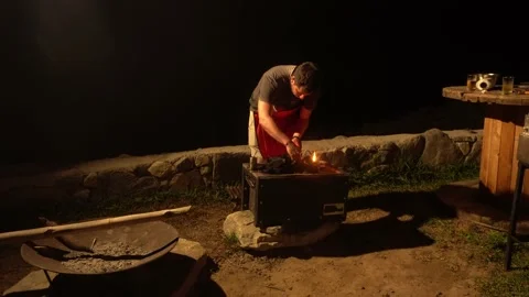 A man lighting the charcoal in a china box with friends outdoors of a country ho 库存影片 199527251