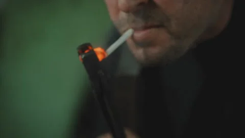 Man lighting a cigarette on a piece of hot glowing metal Stock Footage 275166751