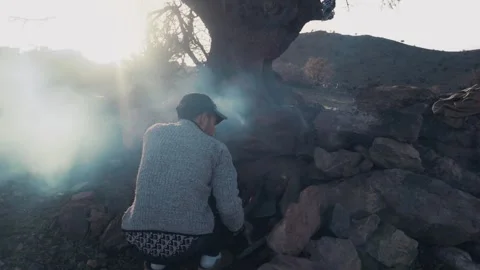 Man Lighting Fire Among Ancient Rocks at Dawn in Tiznit Morocco Stock-Footage 332776727