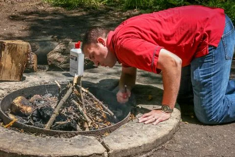 Man Lighting Fire in Firepit Foto stock