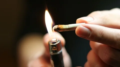 Man lighting marijuana cigarette joint roach Stock Footage 96796011