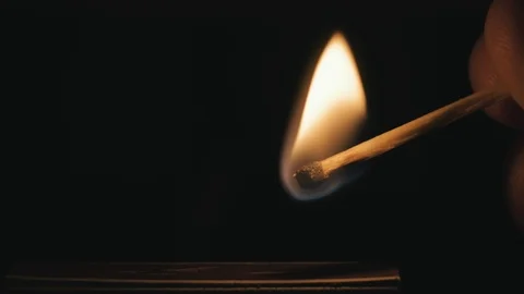 Man lighting a match from a matchbox, then shortly after, blowing it out. Stock Footage 123076537