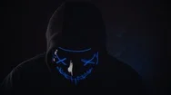 Man With Lighting Neon Glow Mask In Hood Raises His Head And Scream In Camera On Stock Footage