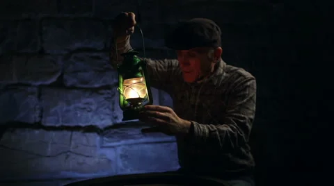 Man lighting an old oil lamp in darkness Stock Footage